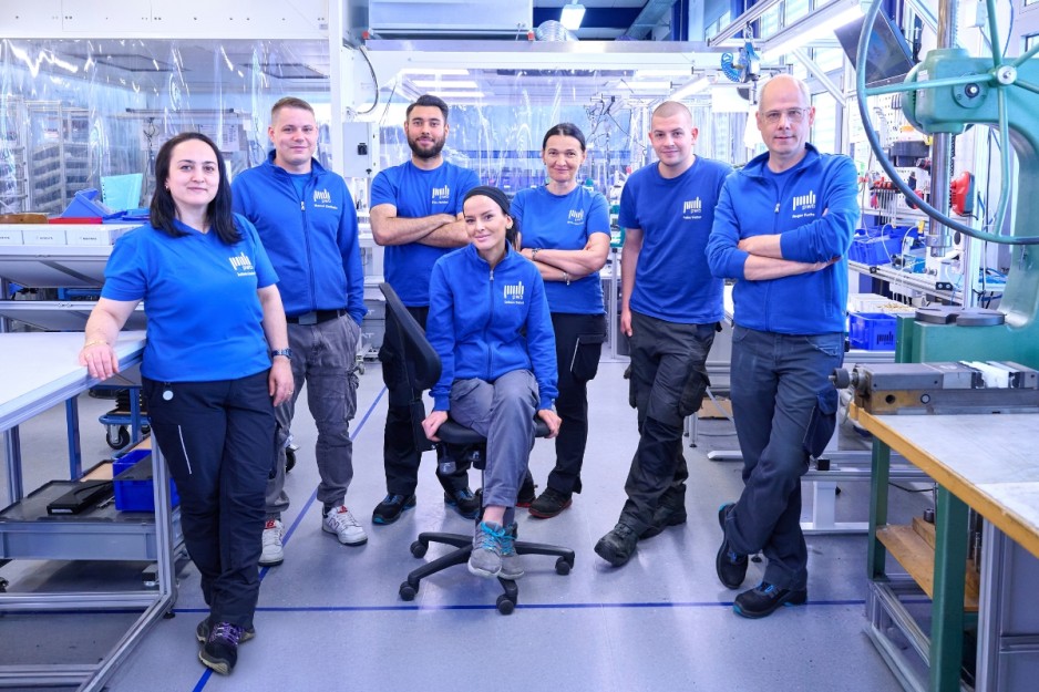 Team der PWB AG Montage & Logistik Abteilung Frauen und Männer stehen vor Reinraum ISO13485
